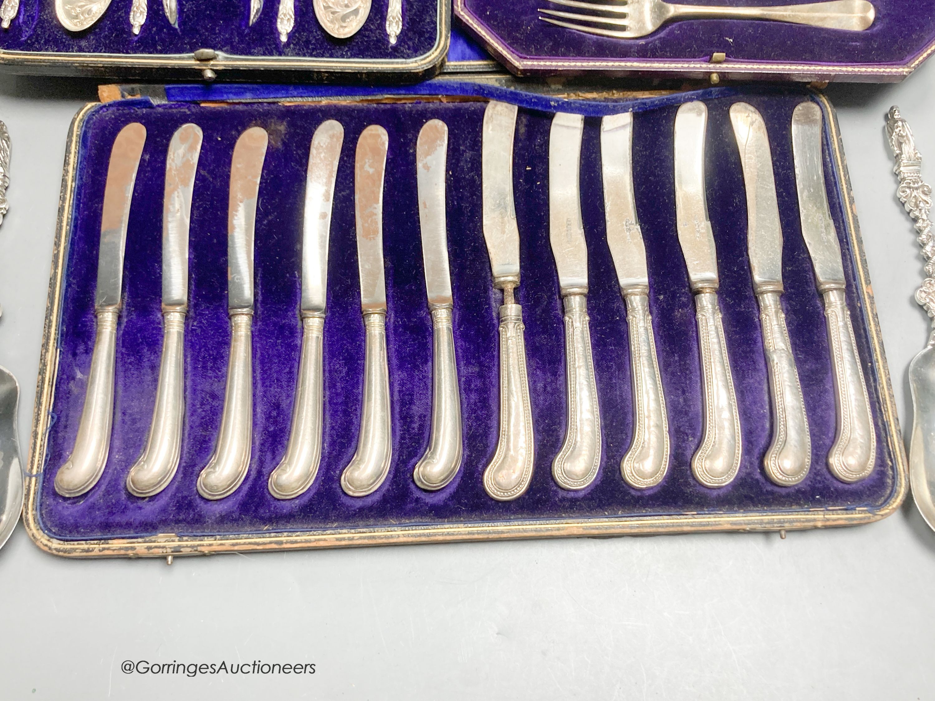 A pair of late Victorian silver apostle serving spoons, William Hutton & Sons Ltd, London, 1895, 20.4cm and three cased sets, including christening set, cake knives and plated apostle spoons